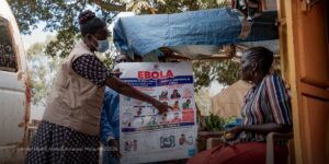 Christine Lanyero, membre du personnel Amref, mène des activités de sensibilisation au sein de la communauté – ici avec Gloria Alesi (assise).
